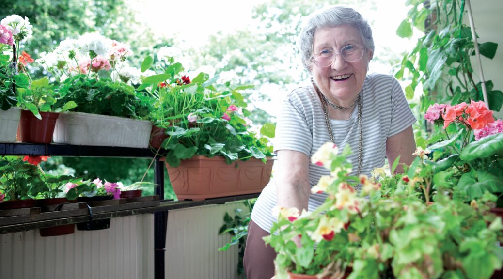 Older lady in a yard with garden plants