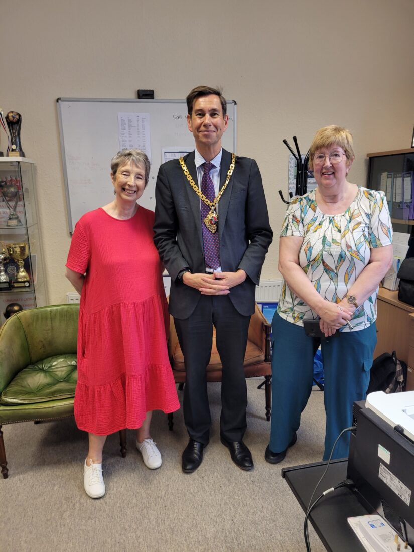 Three people stood in a line. Councillor Dr Matt Lamb stood in the middle wearing his Mayoral chain