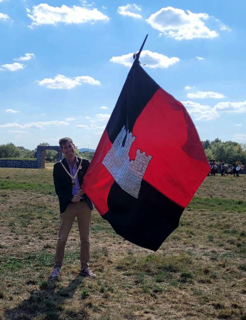 The Mayor holding a flag