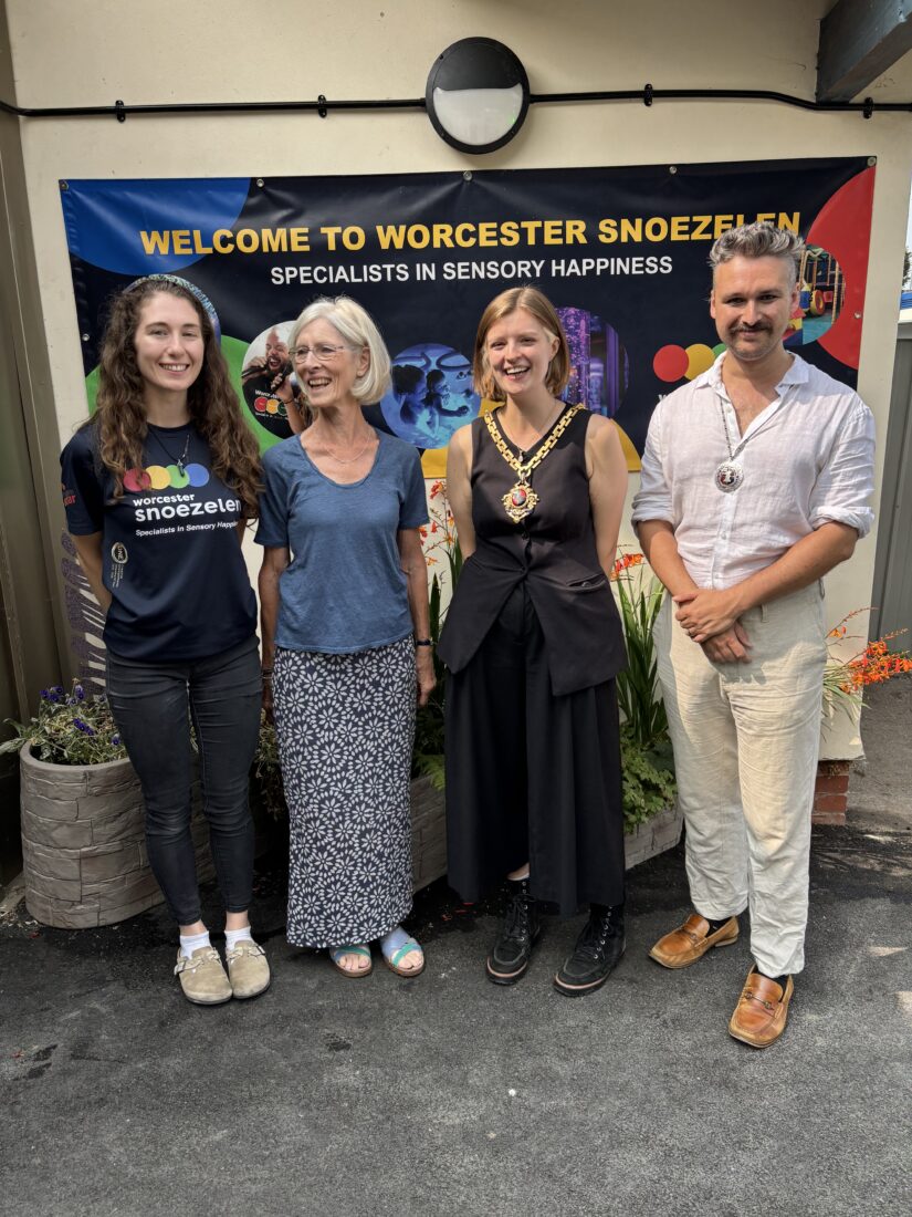 Four people standing in front of a sign that reads, "Welcome to Worcester Snoezelen"